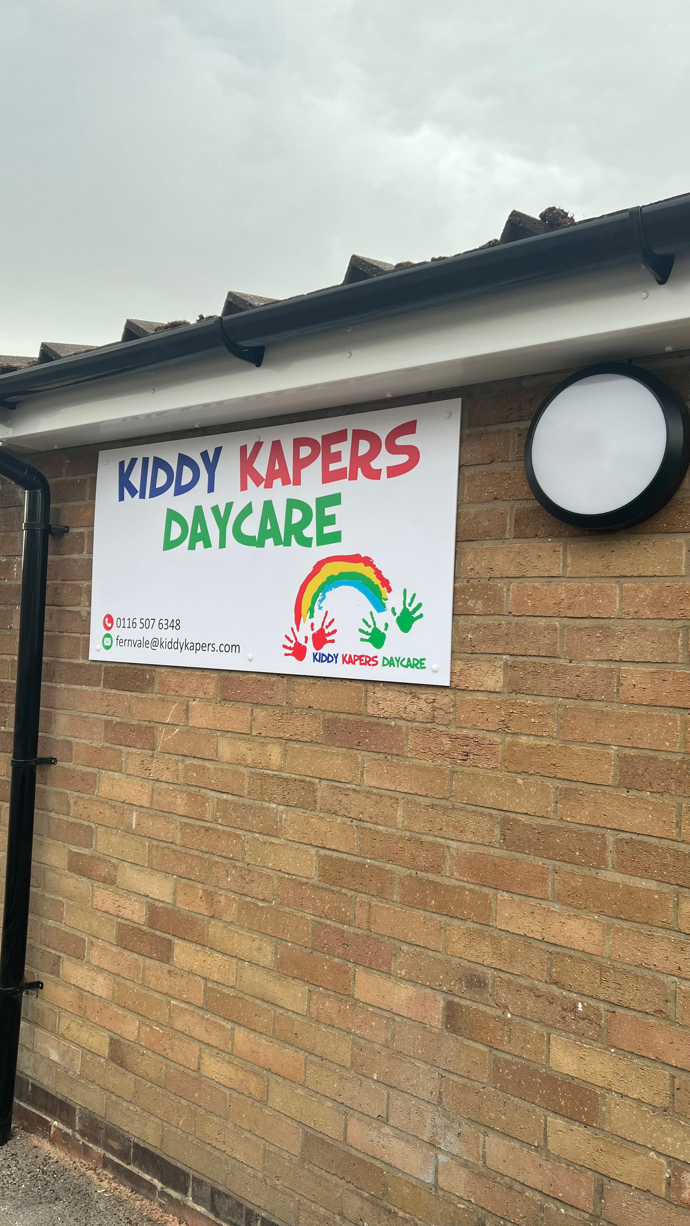 Kiddy Kapers Thurnby exterior — brick wall with rainbow logo signage at the entrance
